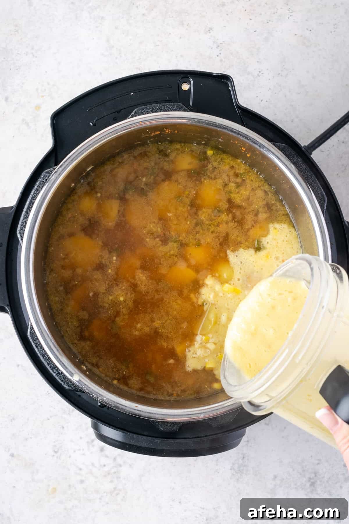 Pureed soup being poured into the instant pot.