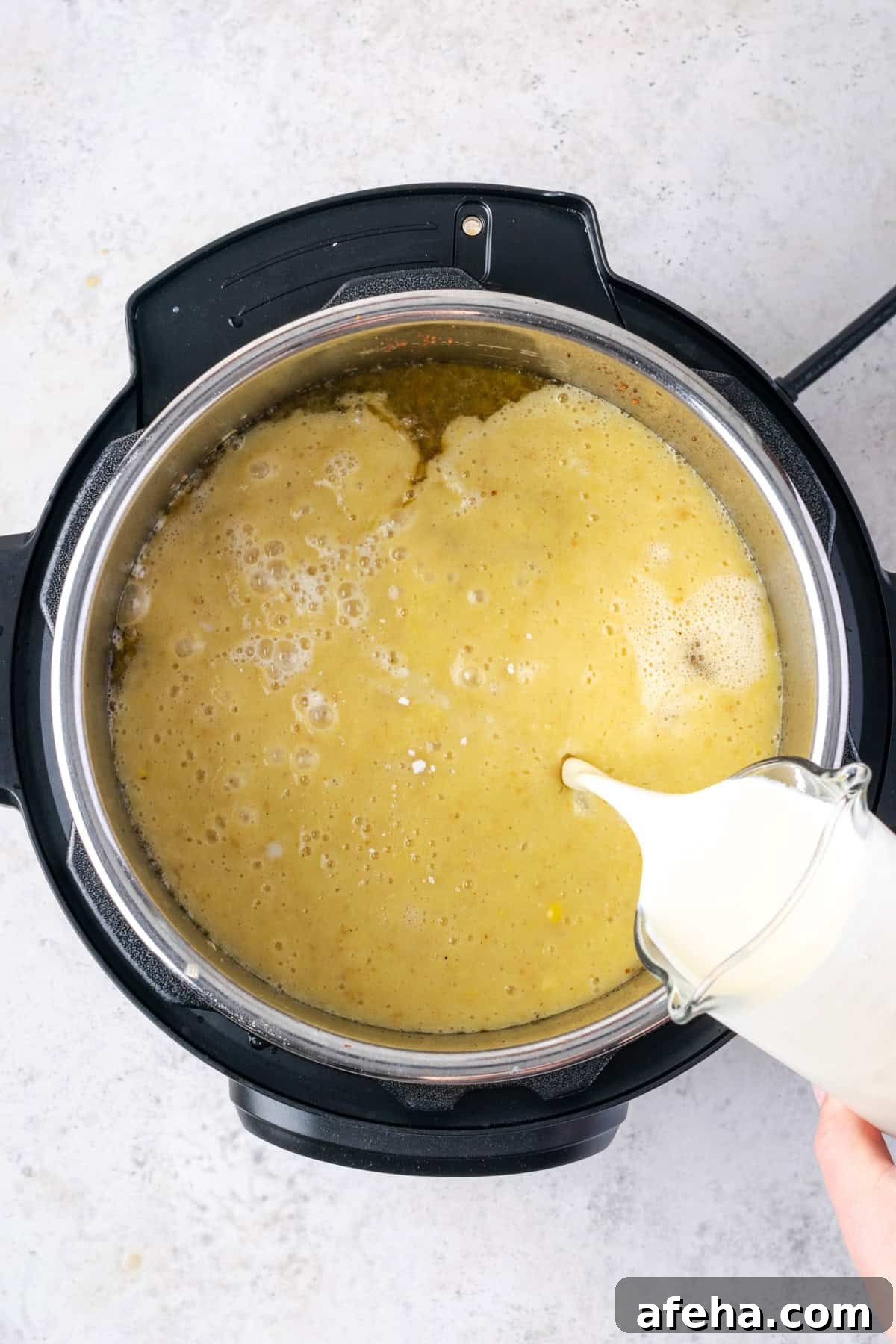 Milk being poured into the cooked soup.