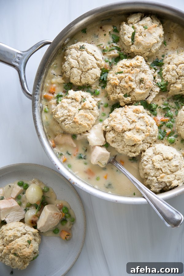 gluten-free chicken pot pie in a pan with spoon and portion on a plate