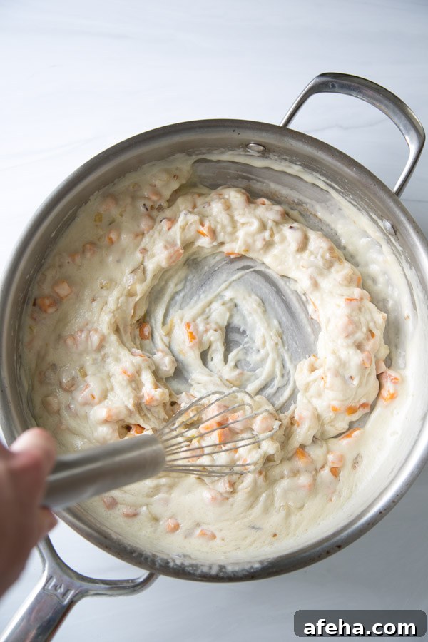 whisking gluten-free bechamel for dairy-free chicken pot pie in a saucepan