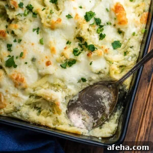 Baking dish with Italian baked mashed potatoes and spoon.
