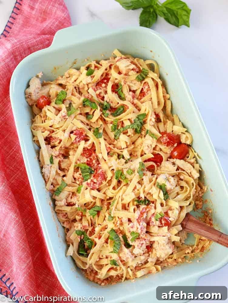 overhead photo of baked feta pasta mixed together in a casserole dish with a serving spoon in the bowl