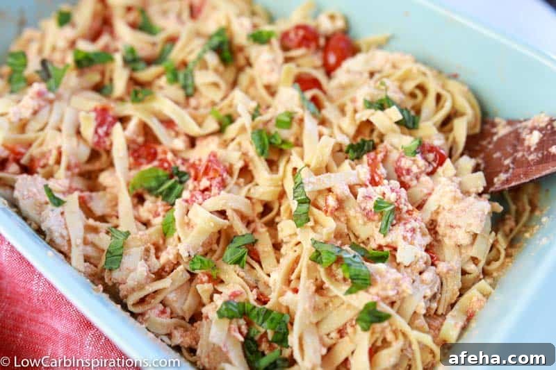 low carb pasta mixed together with feta cheese, cherry tomatoes, minced garlic and olive oil in a casserole dish
