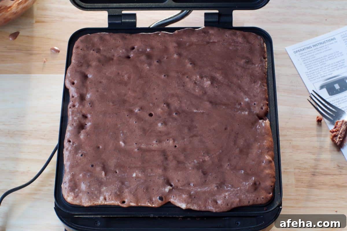 waffle batter poured onto hot prepared waffle iron