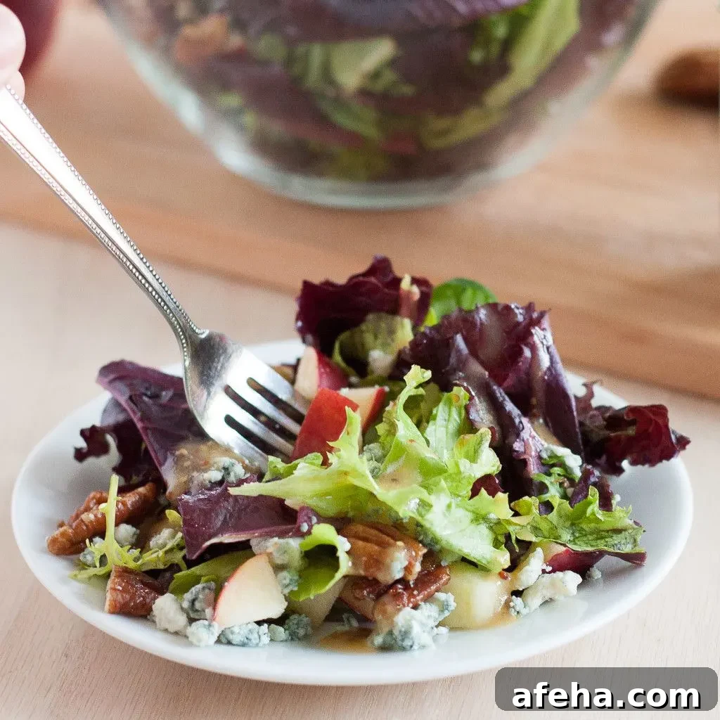 This salad is perfect for fall! Blue cheese crumbles, quick candied pecans, fresh apples, dark leafy greens, and an easy red wine vinaigrette. It's healthy fall comfort food! 