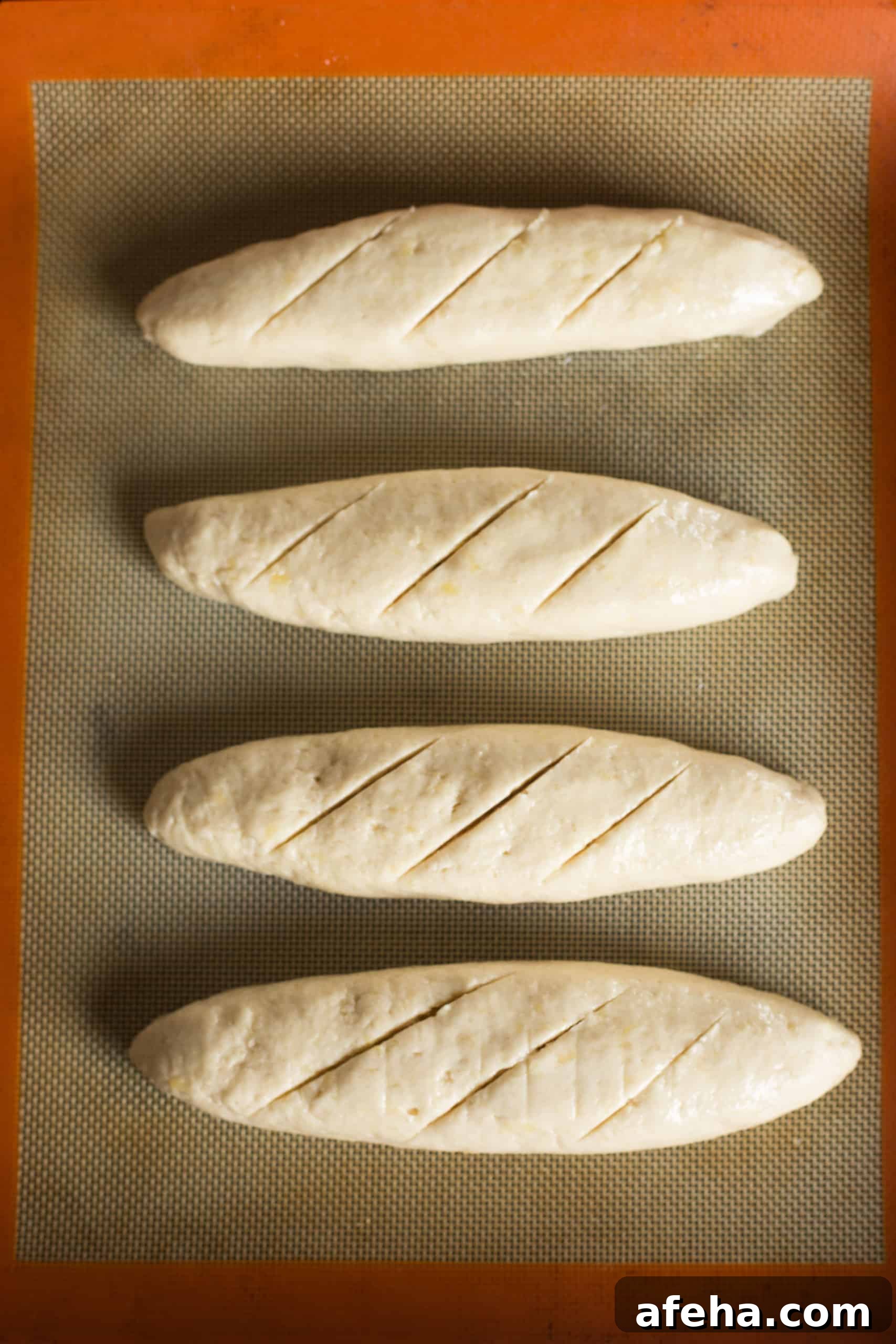 Dairy-free baguette dough with lines scored on top.