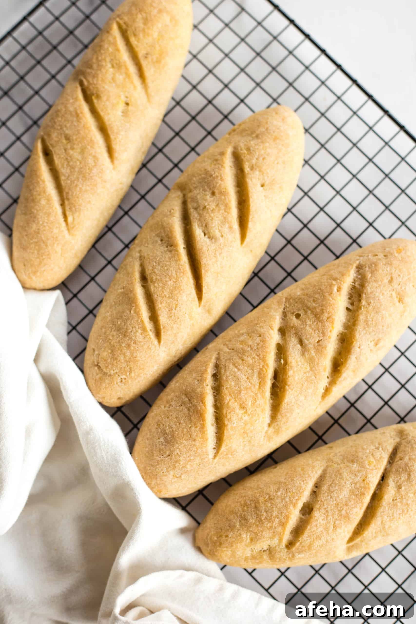 Freshly baked baguettes cooling on wire rack.