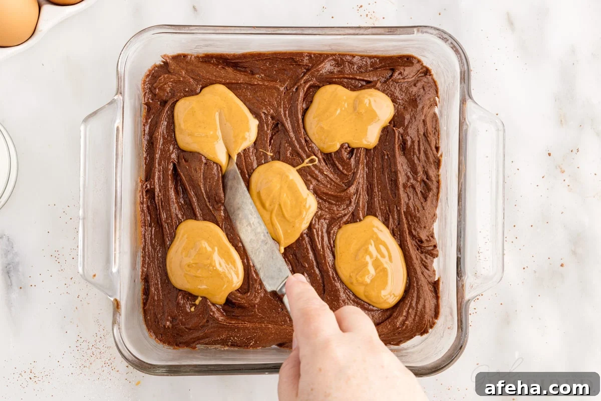 Dollops of peanut butter over the brownie batter in 8x8 pan.