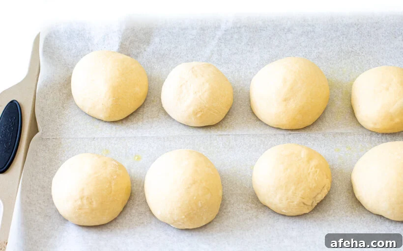 portioned burger buns on baking sheet