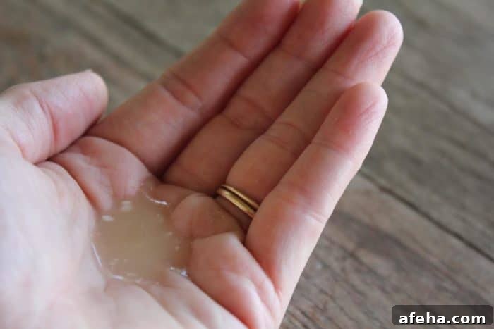 Image shows a hand holding a small amount of homemade shampoo