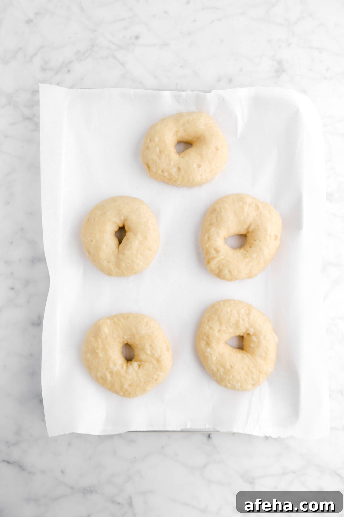 boiled bagels on lined sheet pan