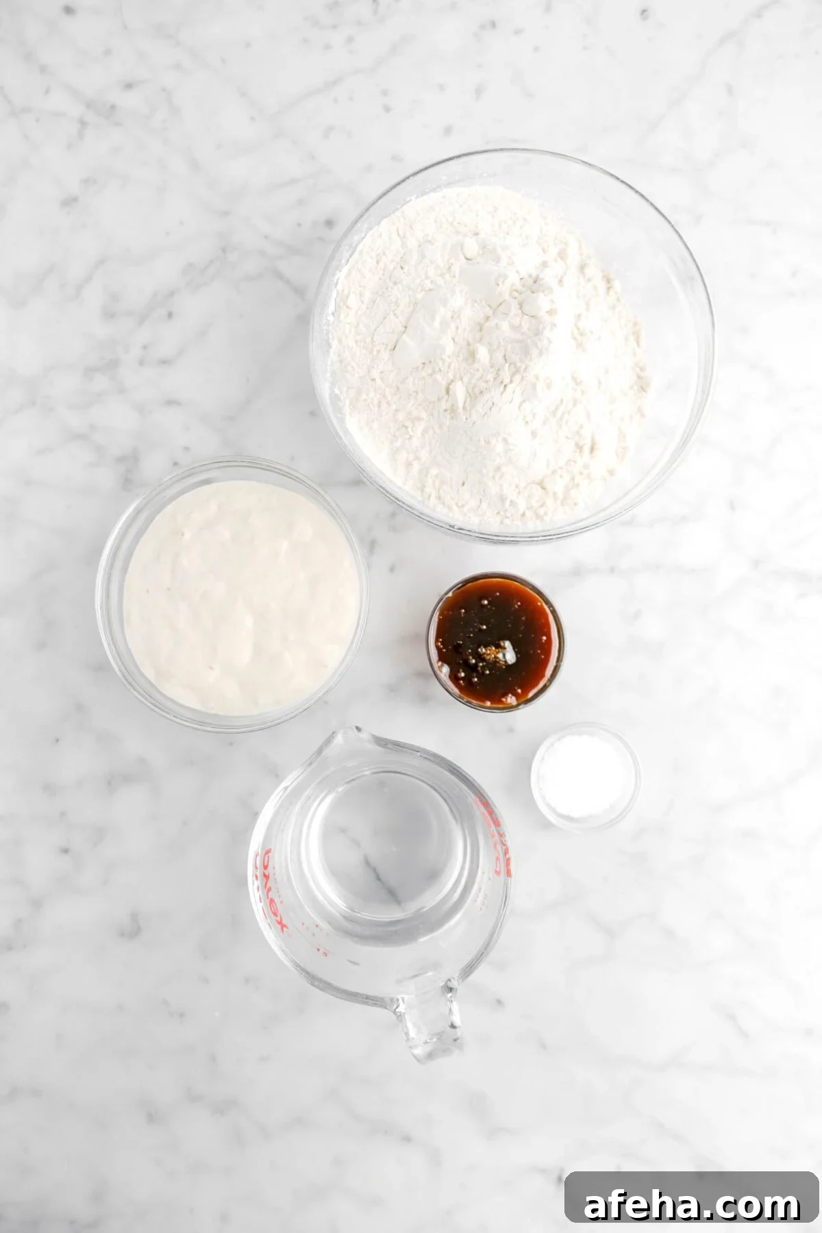 flour, sourdough starter, barley malt, salt, and water on marble counter