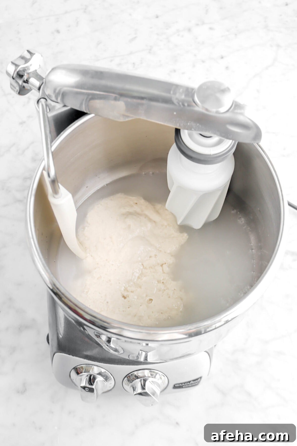 water and sourdough starter in mixer