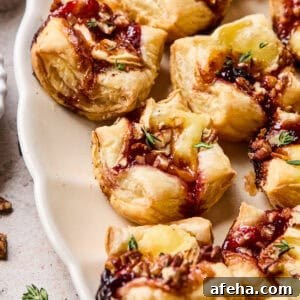 Puff pastry brie bites on serving platter.