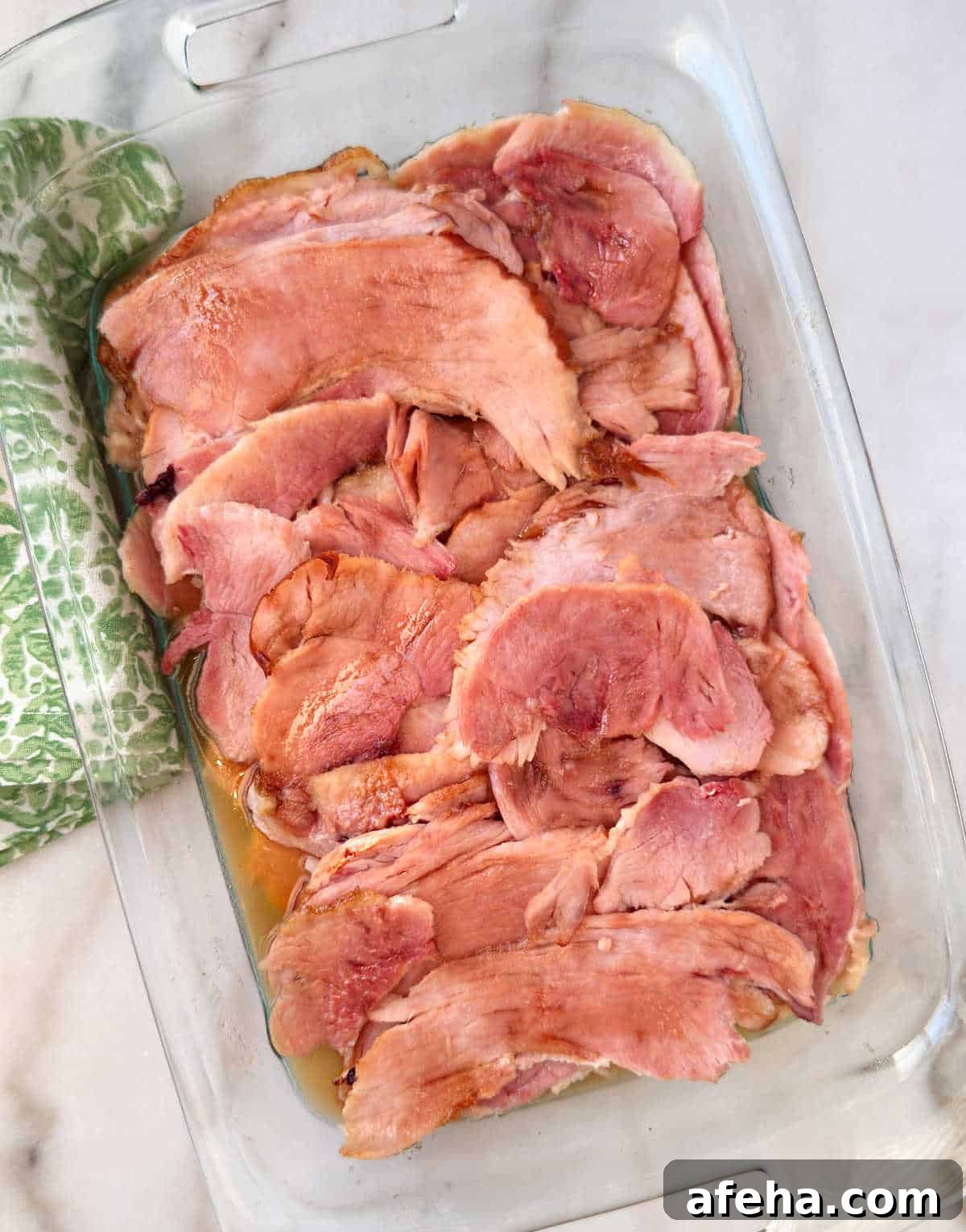 Oven-Baked Ham Slices: Quick Recipe for Perfectly Crispy Edges 2 baked ham slices with brown sugar in baking dish.