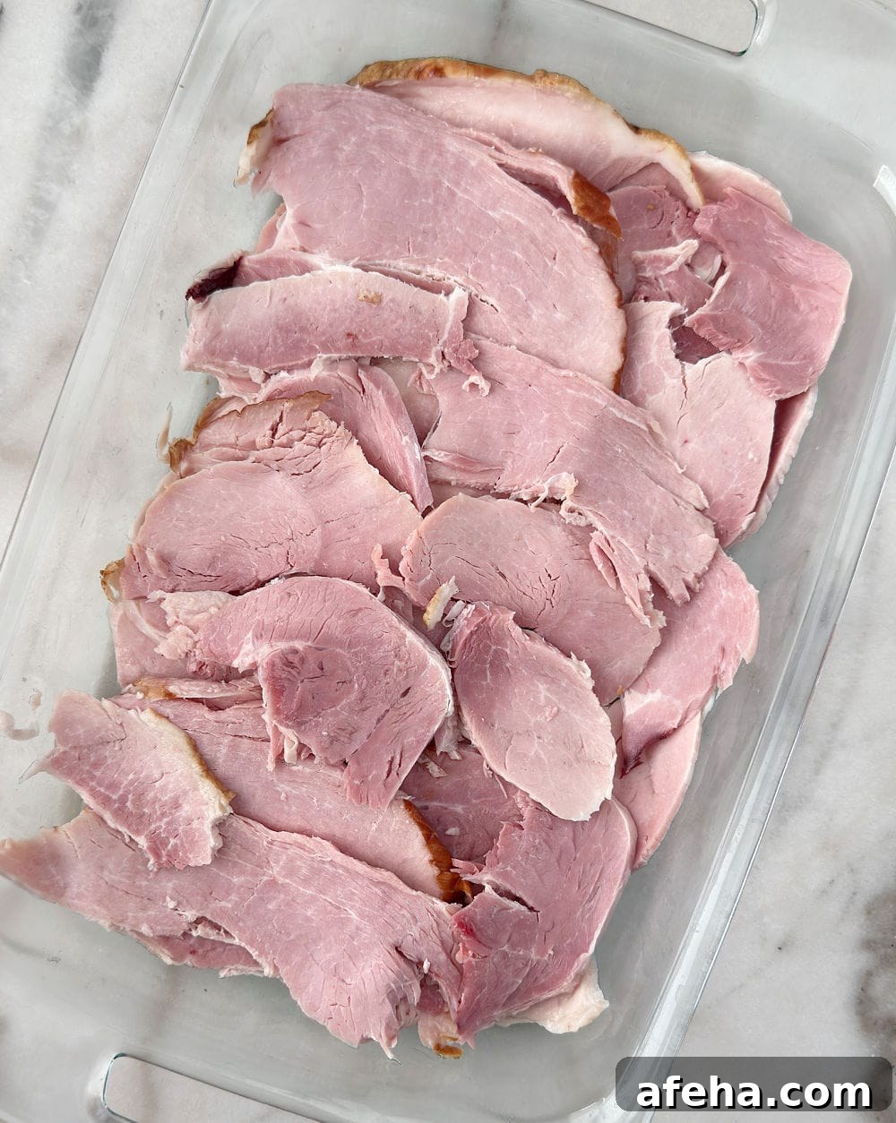 Oven-Baked Ham Slices: Quick Recipe for Perfectly Crispy Edges 5 slices of ham in casserole dish.