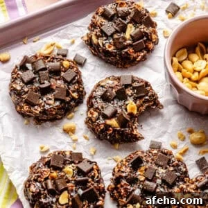 a close-up of chocolate oat cookies with salted peanuts on a baking sheet