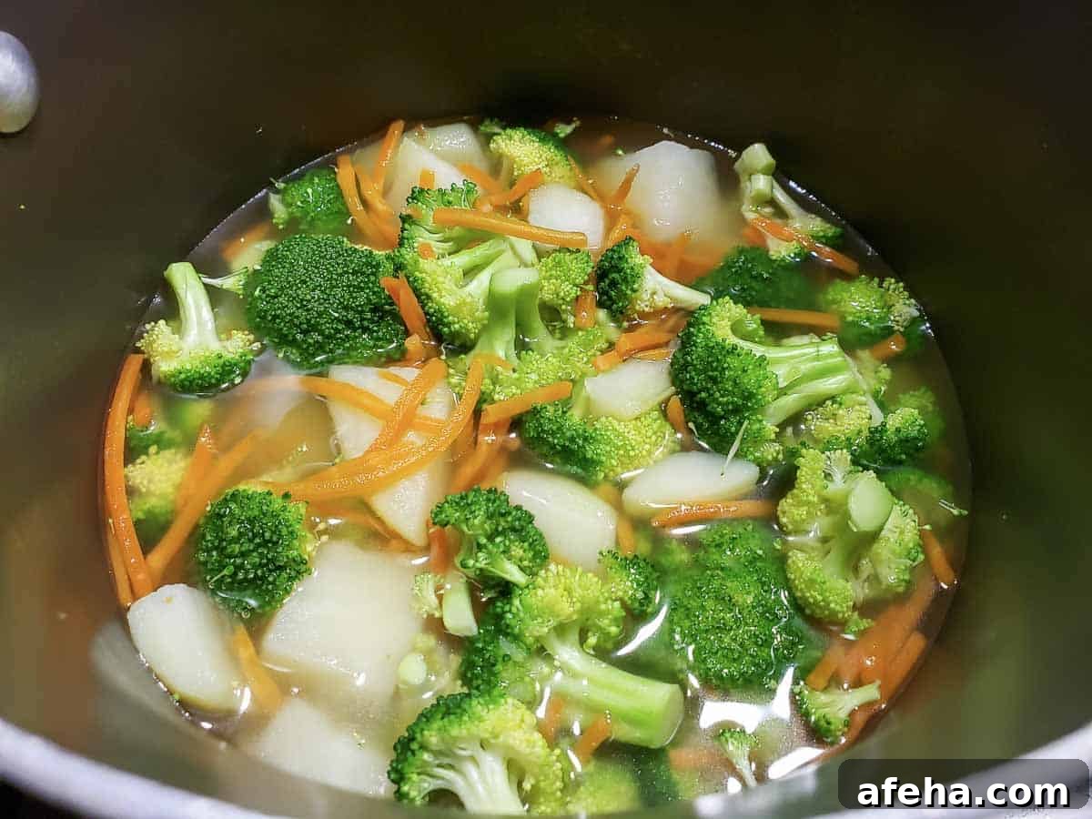 Creamy Cheddar Vegetable Soup Recipe for Cozy Weeknights 6 Chunky Veg Soup cooking in a pan.