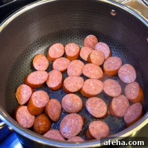 Authentic Red Beans and Rice Recipe for Weeknight Comfort Meal 4 Sausage being browned in a pot.