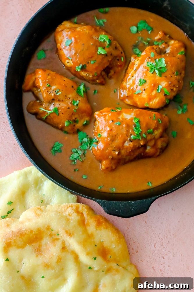 chicken with orange sauce and cilantro on it in a skillet