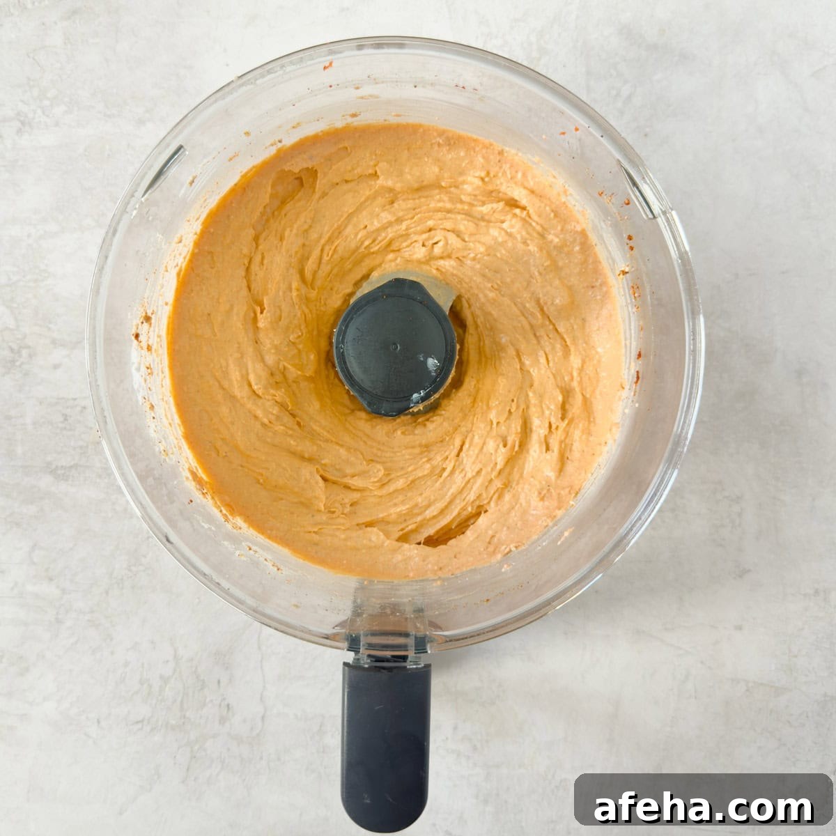 Creamy orange smoked salmon dip in the bowl of a food processor.