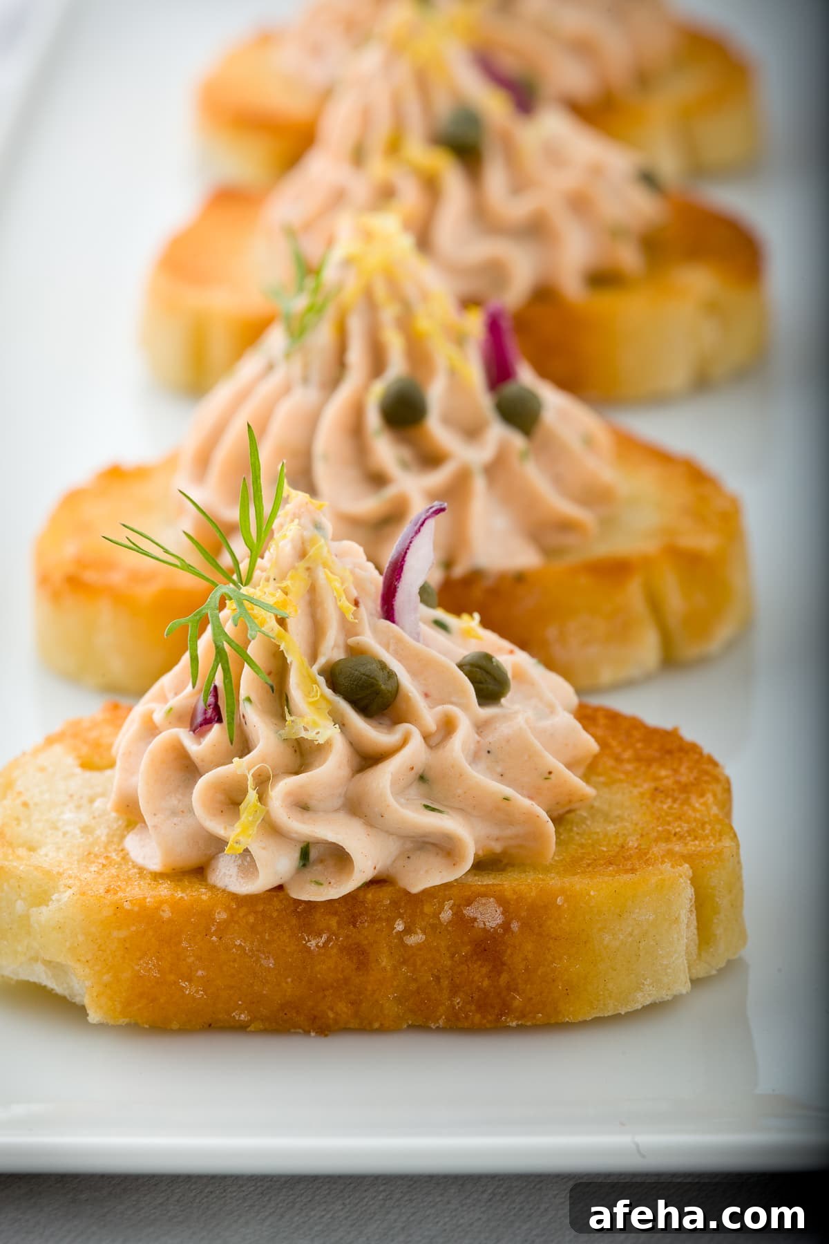 Smoked salmon dip piped onto a crostini.