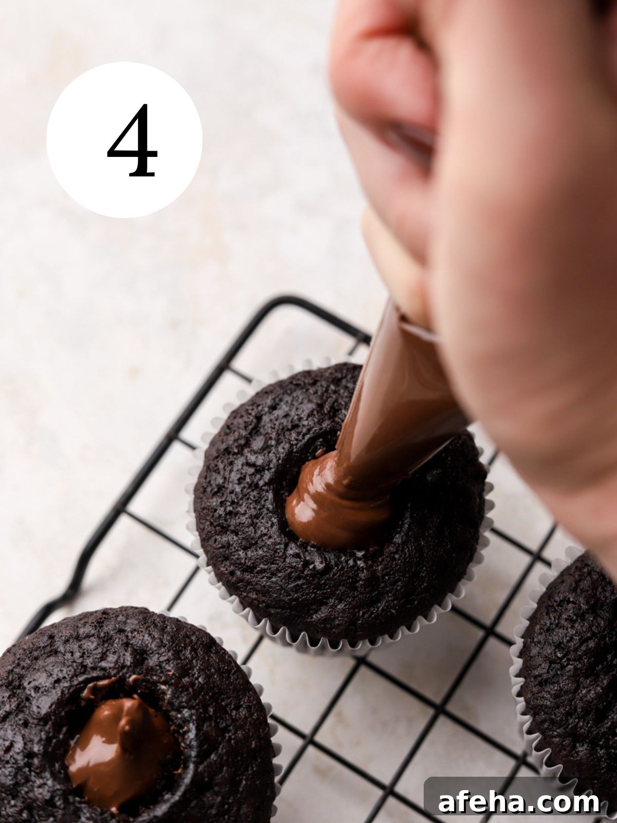 Piping Nutella into cupcake