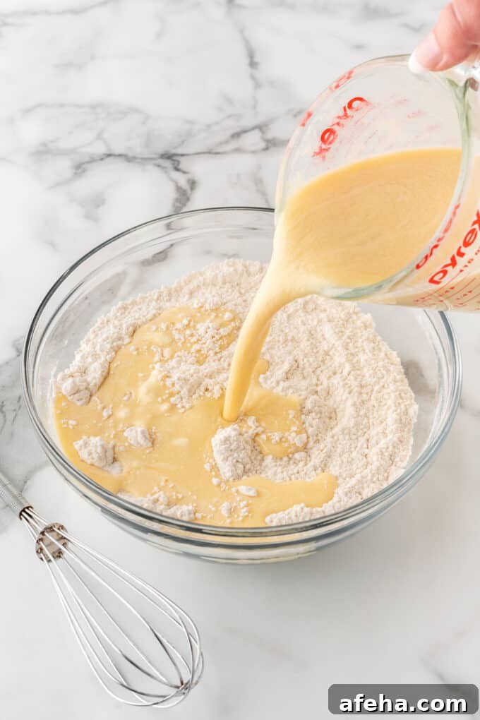 pouring wet ingredients into dry ingredients to make crispy waffles