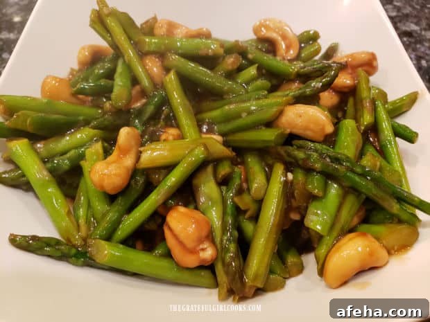 Asparagus Cashew Stir Fry is served in a white bowl.