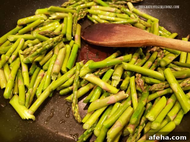 Asparagus pieces are cooked in olive oil for 3-4 minutes in a large skillet.