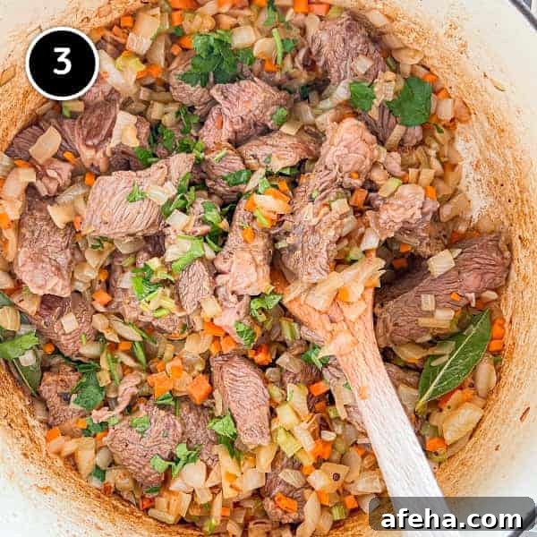 The fried onion, celery and carrot in a pan with the beef with some parsley.