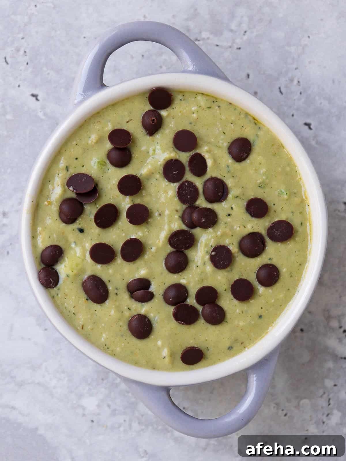 Blended batter in a small ramekin dish with chocolate chips sprinkled on top. Before baked in the oven.