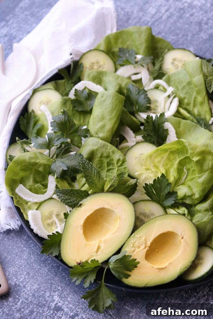 Crisp Butter Lettuce Salad with Lemon Vinaigrette 2 green salad on round platter with serving utensils
