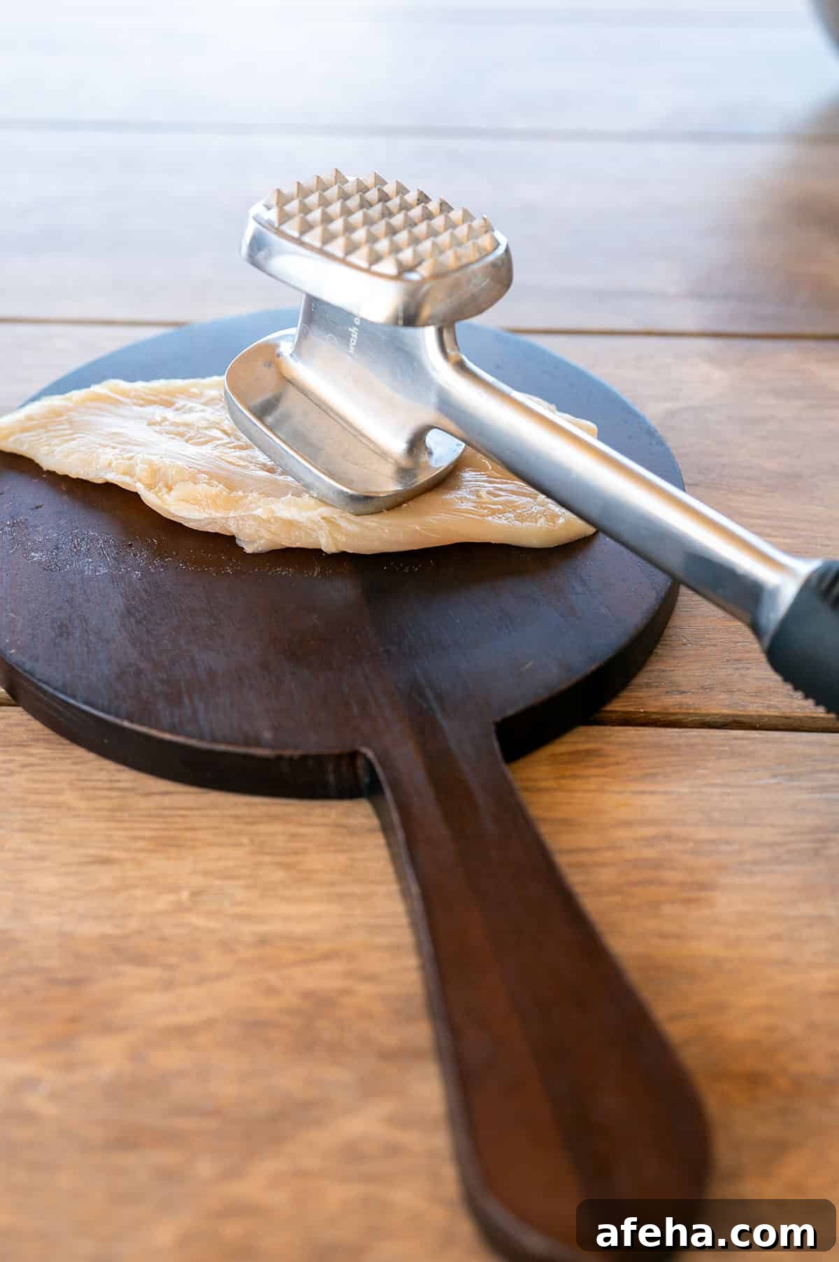 Flattening a chicken breast.