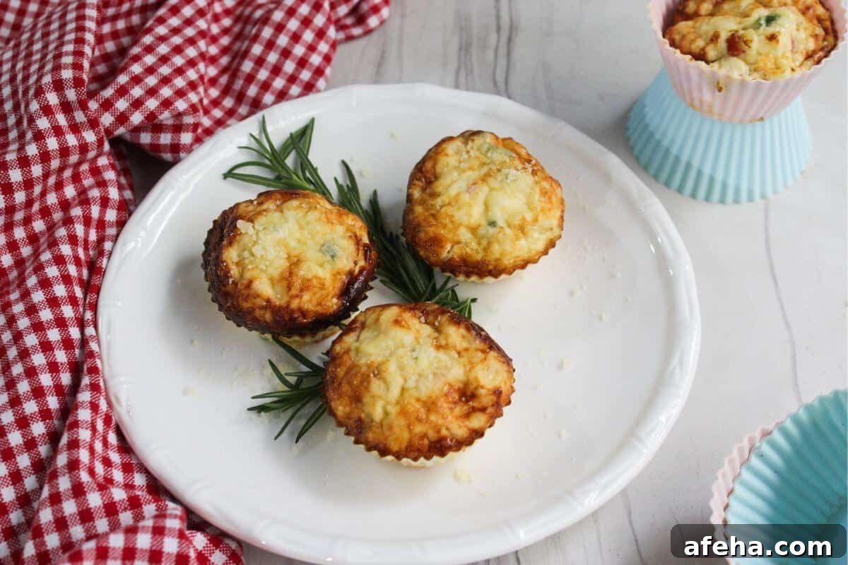 Three egg white frittata muffins on a plate with sprigs of rosemary.