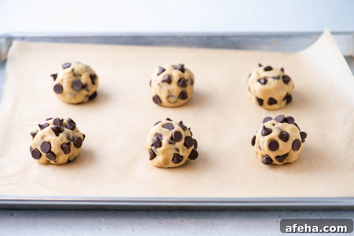 6 balls of cookie dough on parchment-lined baking sheet