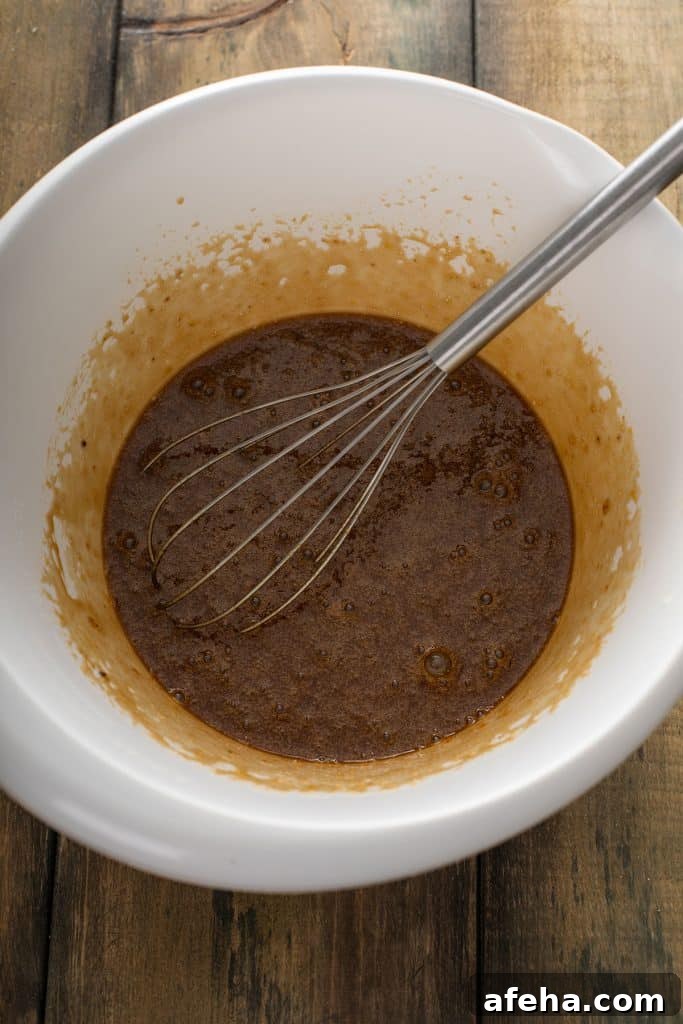 mixed eggs, brown sugar, corn syrup, vanilla extract, melted butter, bourbon and salt in a large mixing bowl with a whisk.