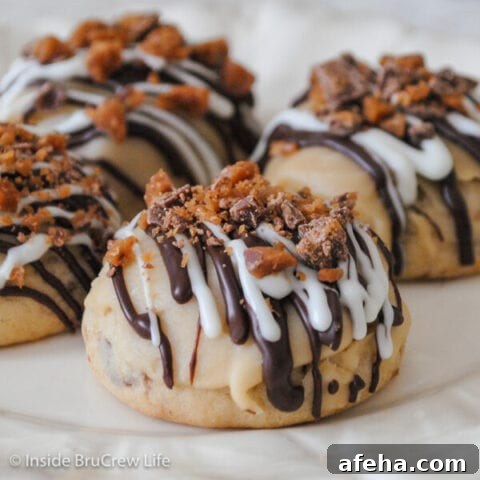 A white plate with toffee cookies drizzled with chocolate and toffee bits.