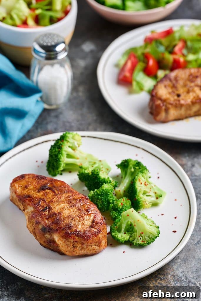 Thick pork chops served with broccoli on a white plate