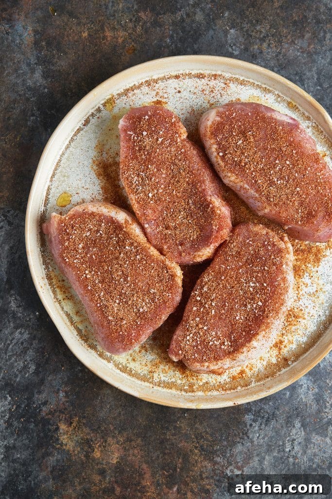Raw pork chops rubbed with spice mix