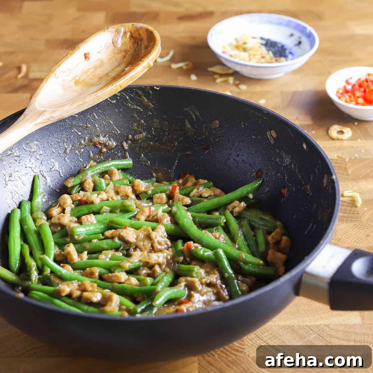 Vegan San Choy Bau Recipe: Flavorful Plant-Based Lettuce Wraps 13 photo of a wok containing vegan chinese green beans and tempeh recipe on a butcher block surface
