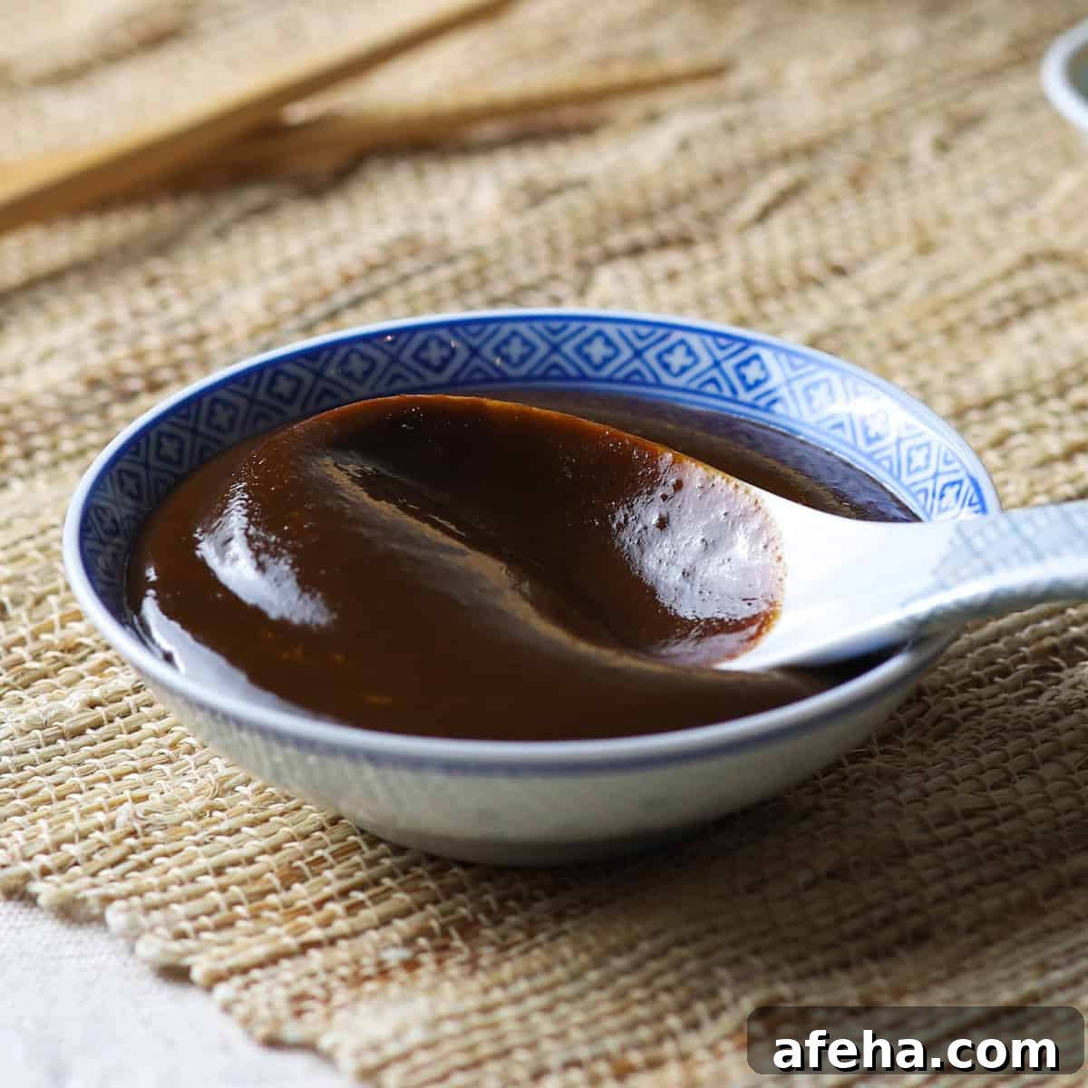 Vegan San Choy Bau Recipe: Flavorful Plant-Based Lettuce Wraps 14 Close-up photo of a shallow Chinese bowl filled with homemade hoisin sauce and a Chinese ceramic spoon