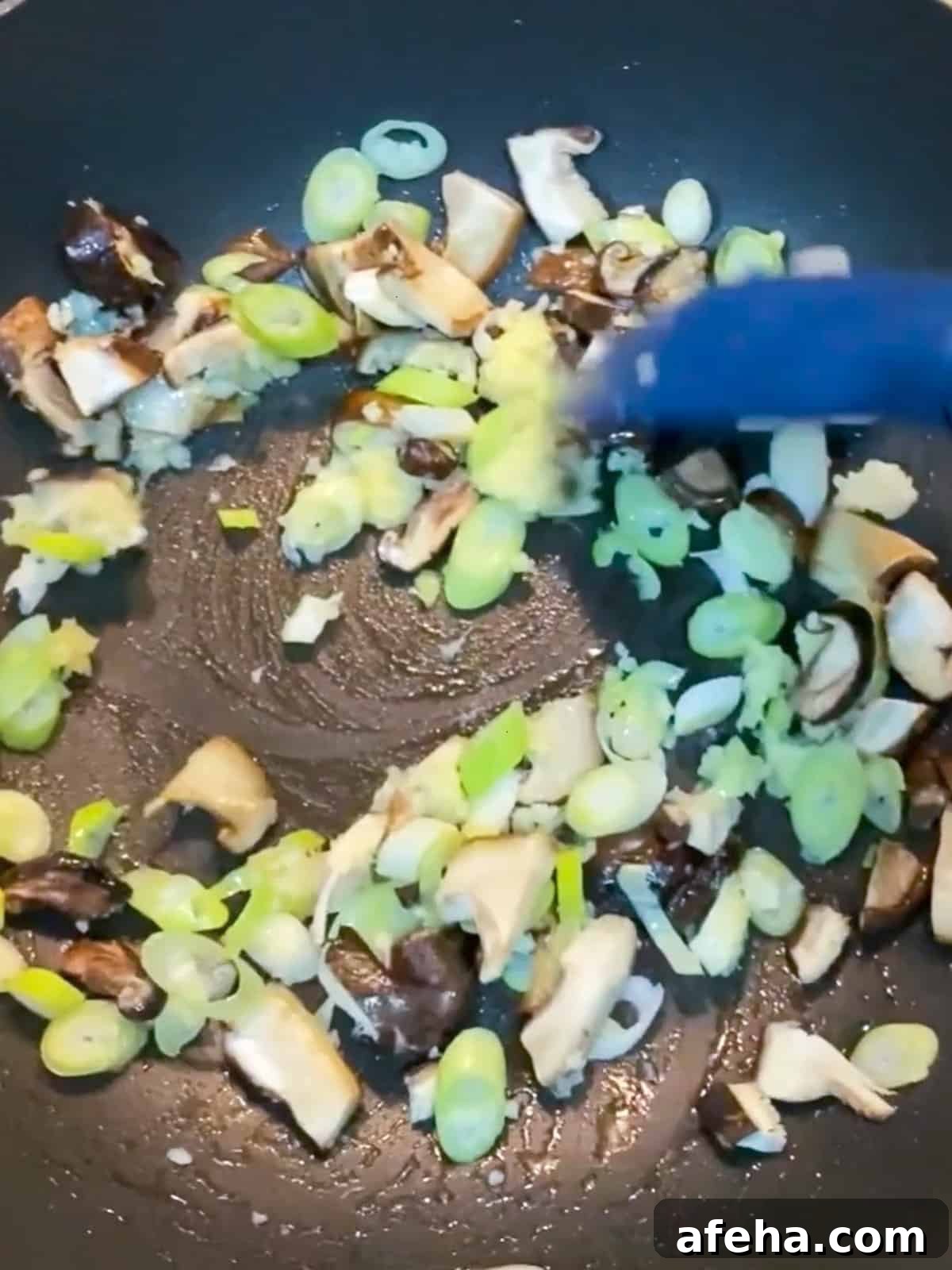 Vegan San Choy Bau Recipe: Flavorful Plant-Based Lettuce Wraps 6 Photo of stir-frying garlic, ginger, mushrooms and spring onions.