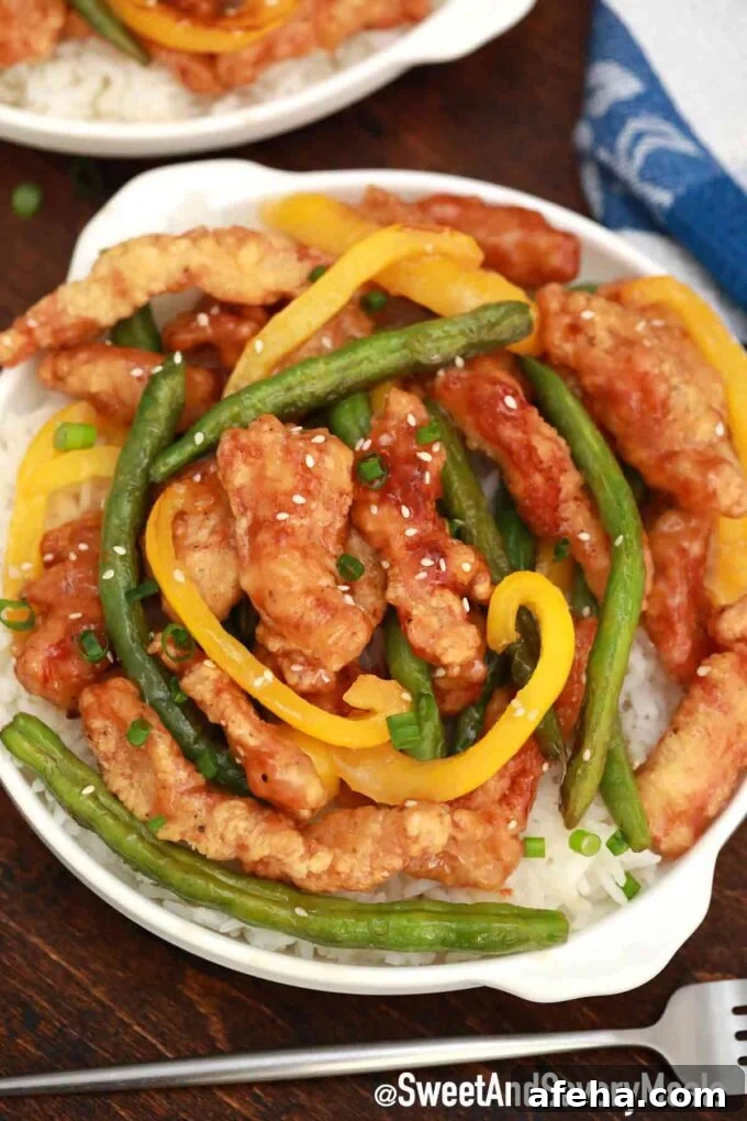 Crispy Panda Express honey sesame chicken with green beans and bell peppers.