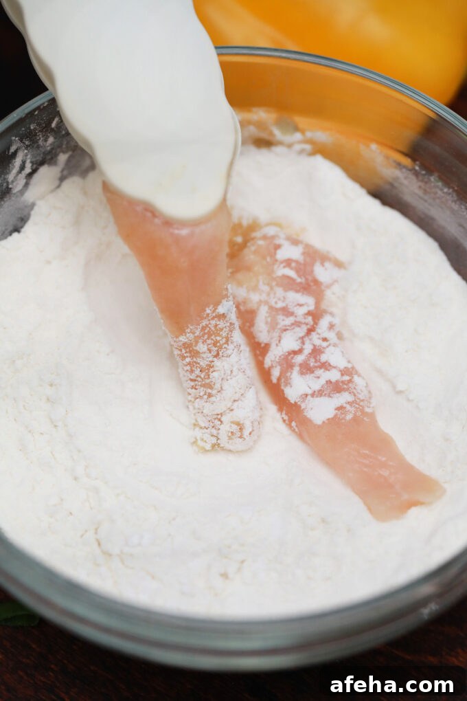 Coating chicken strips in flour and cornstarch.
