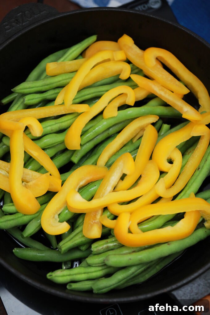 Sautéing sliced bell peppers and string beans.