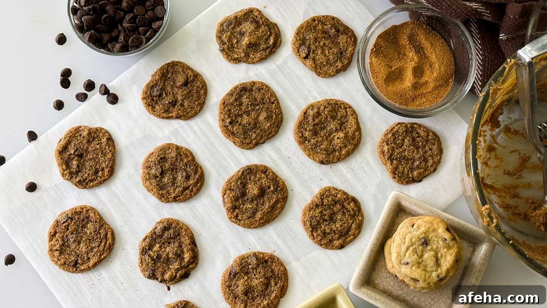 Baked chocolate chip cookies on a sheet of parchment paper.