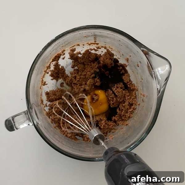 Adding the egg and mixing it in with the creamed butter and sugar.