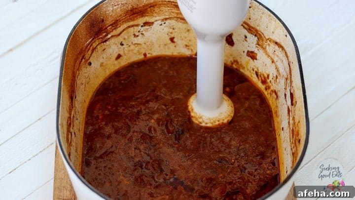 Birria Tacos with Rich Consommé: Where to Eat and How to Make Them 8 Using a handheld blender to smooth the consomme dipping sauce for the birria tacos.
