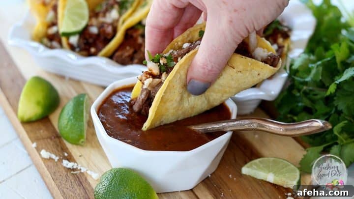 Birria Tacos with Rich Consommé: Where to Eat and How to Make Them 9 Dipping a birria taco in the consomme dipping sauce.